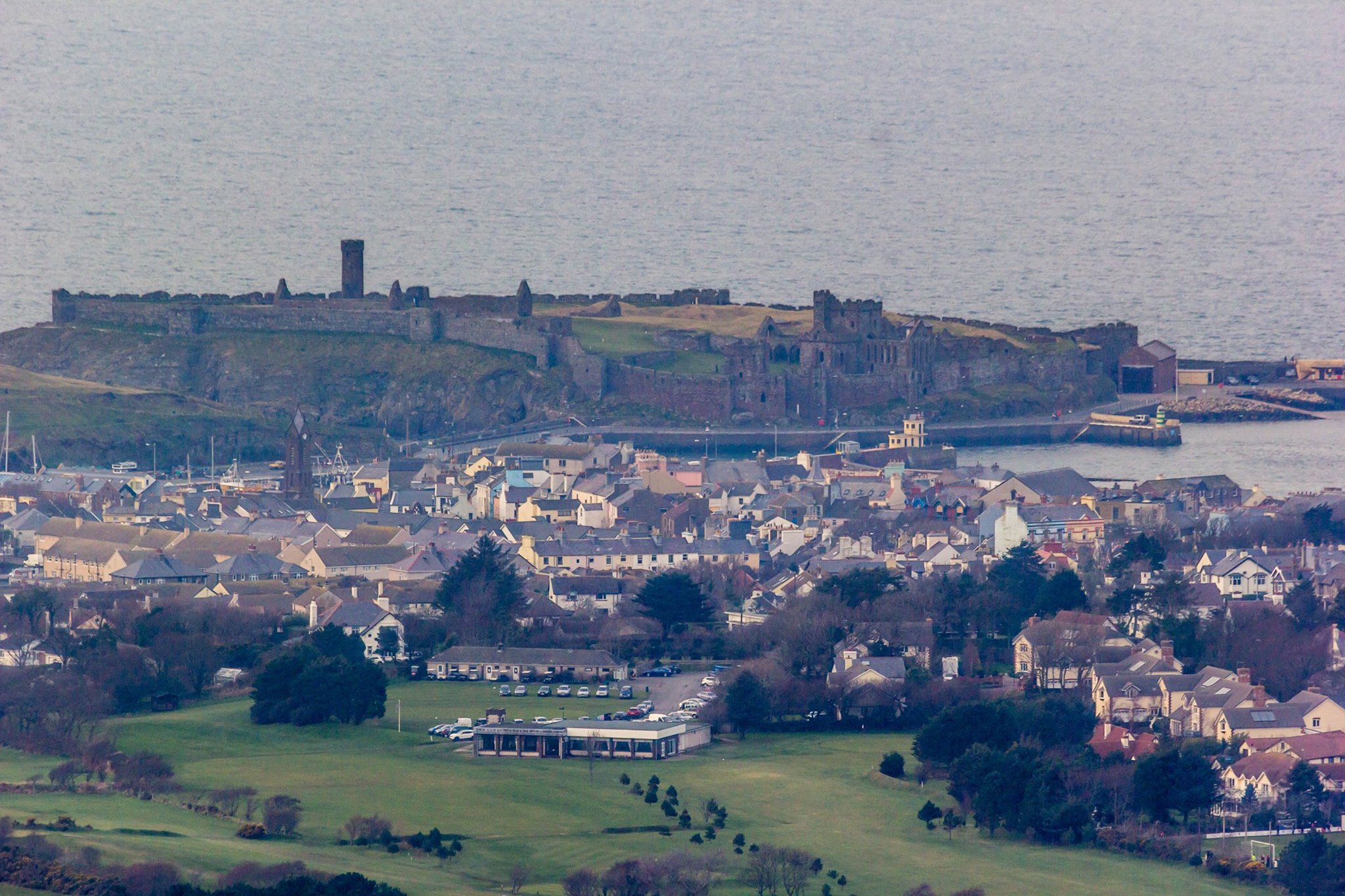 Looking at Peel Castle over part of Peel and the Golf Course Club House from the Cairn, by Paul Smith